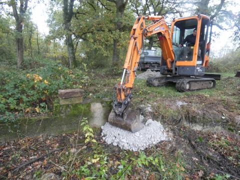 Installation de terre glaise de part et d'autre de l'ouvrage maçonné.