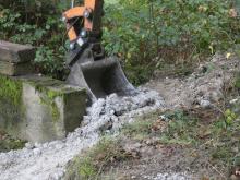 Installation de terre glaise de part et d'autre de l'ouvrage maçonné.